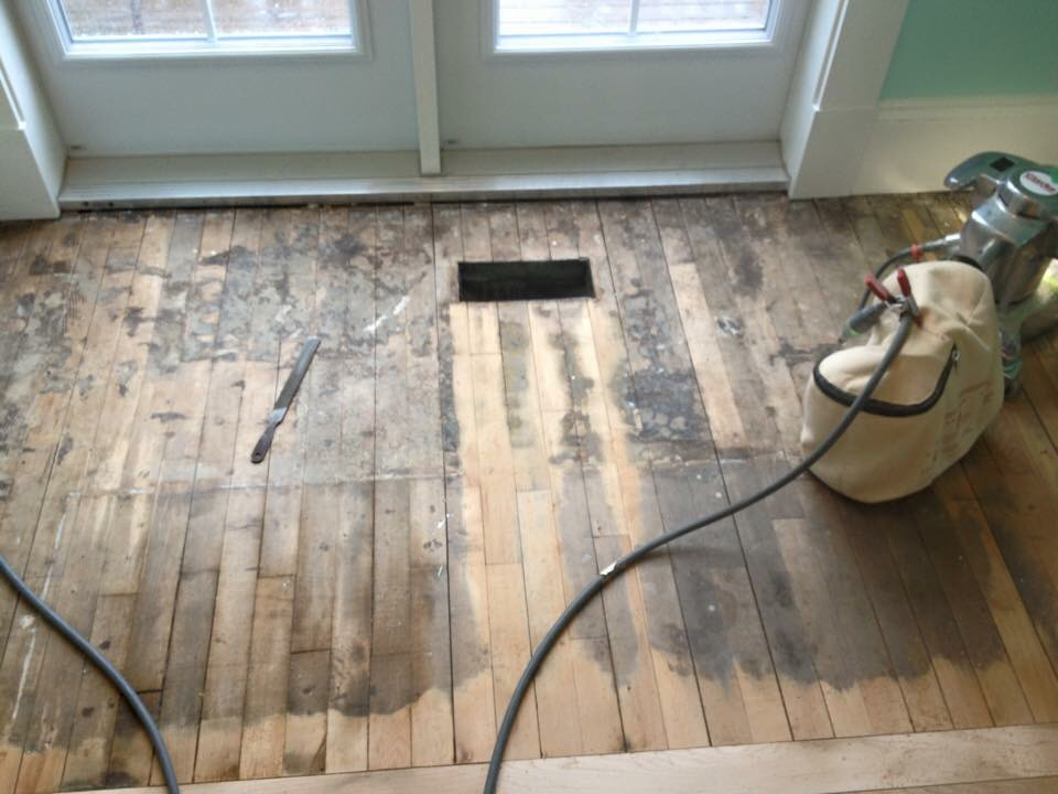 This hardwood floor with carpet glue. Remove the glue, sand and refinish the floor!